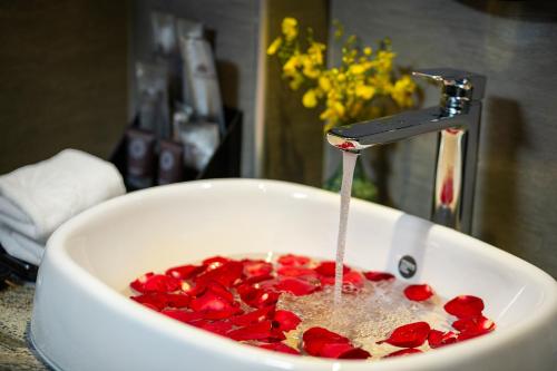 a sink filled with red peppers under a faucet at Hanoi Esplendor Hotel and Spa in Hanoi