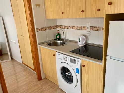 een keuken met een wasmachine en een wastafel bij Apartment in Torrevieja