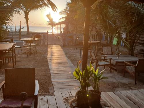 a wooden walkway on the beach with tables and chairs at Memo's Beach in Nilaveli