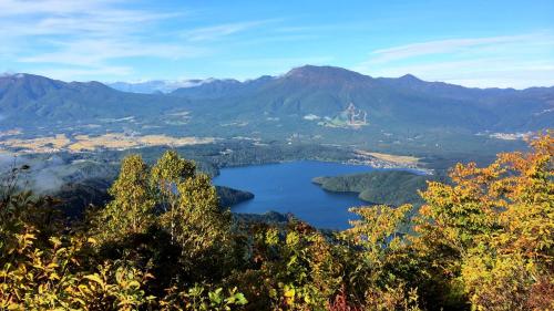 a view of a lake in a valley with mountains at Blueberry Pension Madarao in Iiyama