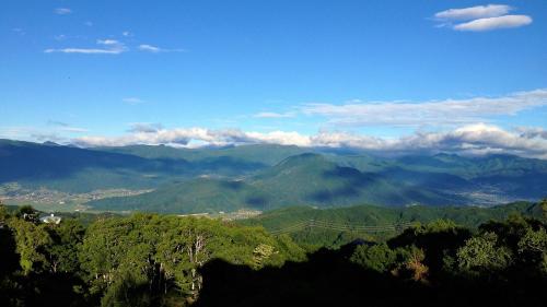 a view of a mountain range with clouds in the sky at Blueberry Pension Madarao in Iiyama