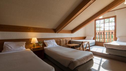 um quarto de hotel com duas camas e uma janela em Blueberry Pension Madarao em Iiyama