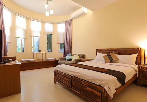 馬公市的住宿－夏天來了民宿，一间卧室配有一张床、一把椅子和窗户。