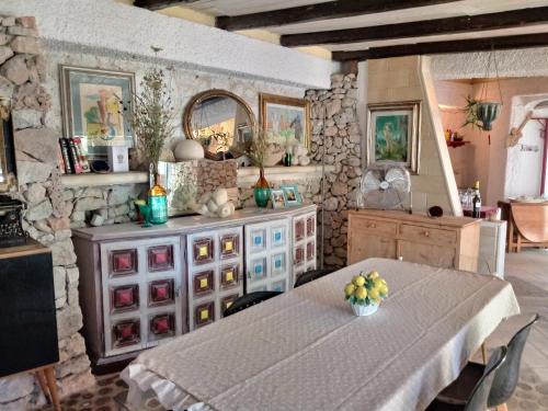 a dining room with a table and a dresser at Limonaia in Salento in Marittima