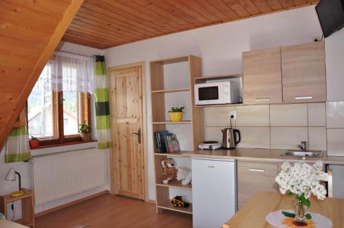 a small kitchen with a table and a microwave at Forester Apartment Zuberec in Zuberec