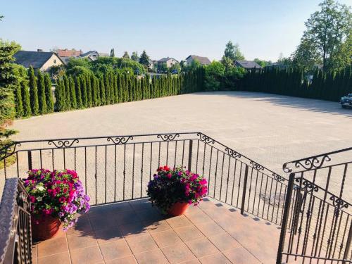 a wrought iron fence with two potted flowers on it at Pas Radvila in Kaišiadorys