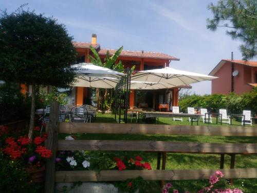 a house with tables and umbrellas in a yard at Agriturismo La Quiete in Roncofreddo