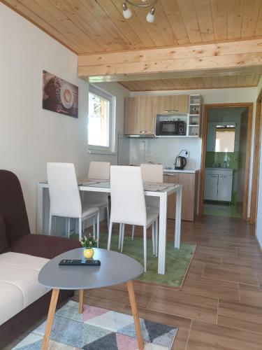 a living room with a table and chairs and a kitchen at Apartments Laura in Rakovica