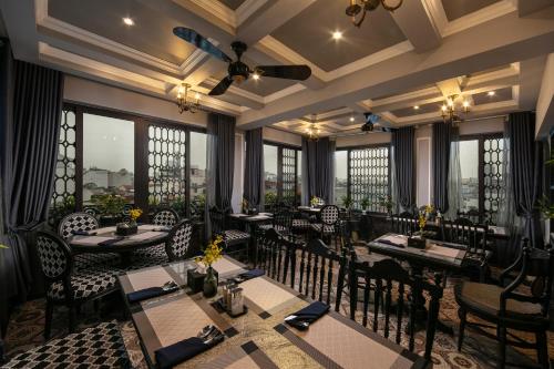 a restaurant with tables and chairs and windows at Hanoi Esplendor Hotel and Spa in Hanoi