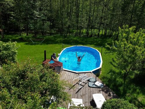 a person in a swimming pool with a dog in it at Chalet Notre Retraite in Ventron