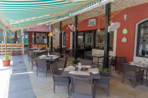 a restaurant with tables and chairs on a patio at Kyriad Prestige Calangute Goa by OTHPL in Calangute