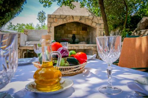 a table with glasses and a basket of vegetables on it at Apartments Ivanka in Ston