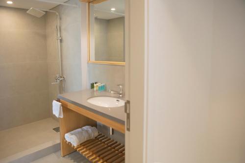 W łazience znajduje się umywalka i lustro. w obiekcie La Siesta Hotel & Beach Resort w mieście Khaldah