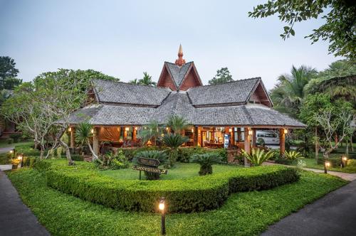 a house with a sign in front of it at Phowadol Resort in Chiang Rai