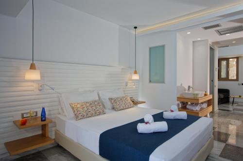 a bedroom with a large bed with towels on it at Archipelagos Hotel in Rethymno Town
