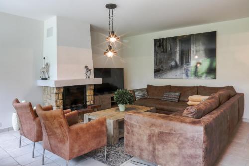 a living room with a couch and a table at Country house - La Mercerie in Continvoir