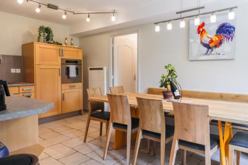 a kitchen and dining room with a wooden table and chairs at Country house - La Mercerie in Continvoir