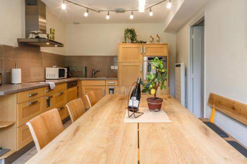 a large kitchen with a wooden table and chairs at Country house - La Mercerie in Continvoir