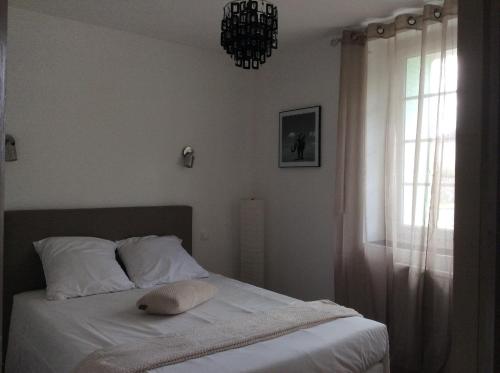 Schlafzimmer mit einem Bett mit weißer Bettwäsche und einem Fenster in der Unterkunft Le Clément'Inn in Noyers-sur-Cher
