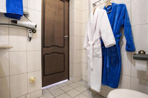 a bathroom with a toilet and a blue robe at Five Stars Wonderland in Krasnoyarsk