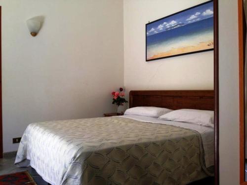 a bedroom with a bed and a painting on the wall at Hotel Giulia in Ustica