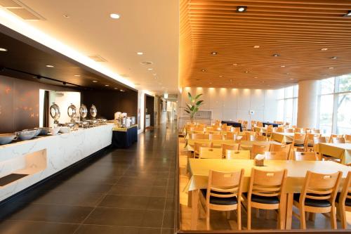 a restaurant with wooden tables and chairs and a bar at The Qube Resort Jeju in Seogwipo