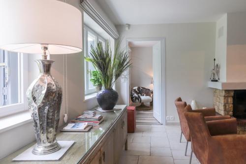 a living room with a table with a vase on it at Country house - La Mercerie in Continvoir