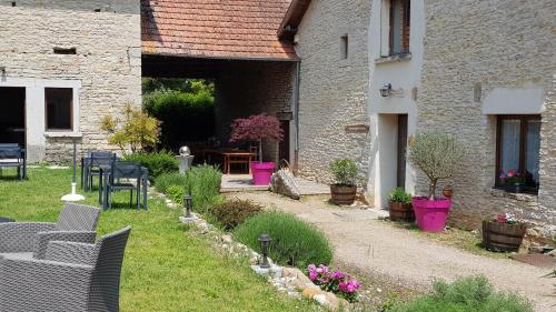 a garden with chairs and plants in front of a building at Auberge du Vernay in Charette