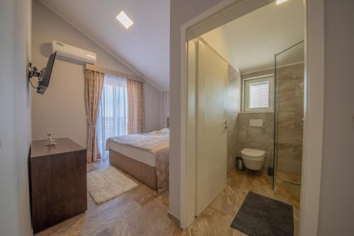 a bedroom with a bed and a shower and a toilet at VILLA Temida Premuda in Premuda