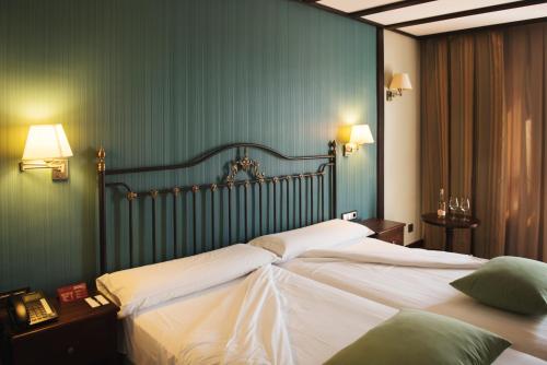 a bedroom with a large bed with white sheets at Complejo Enoturístico Finca La Estacada in Tarancón