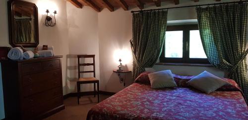 a bedroom with a bed with a dresser and a window at Poggio Al Palio in San Lorenzo a Merse