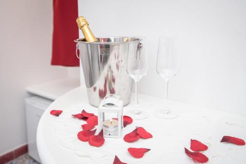 a table with wine glasses and red rose petals at Valle d'Amalfi Suites in Amalfi