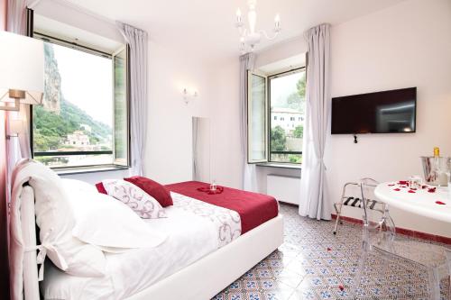 a white bedroom with a bed and a sink and a tub at Valle d'Amalfi Suites in Amalfi