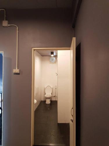 a bathroom with a toilet and a door to a room at SleepCatsHostel in Bangkok