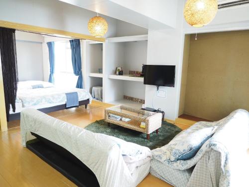 a living room with a couch and a tv at Holiday Homes TSUBOYA 505 in Naha