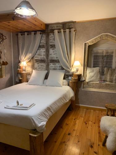 - une chambre avec un grand lit et un miroir dans l'établissement L’allée des peupliers, à Chevigny