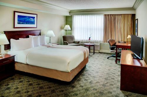 a hotel room with a large bed and a desk at Chateau Nova Kingsway in Edmonton