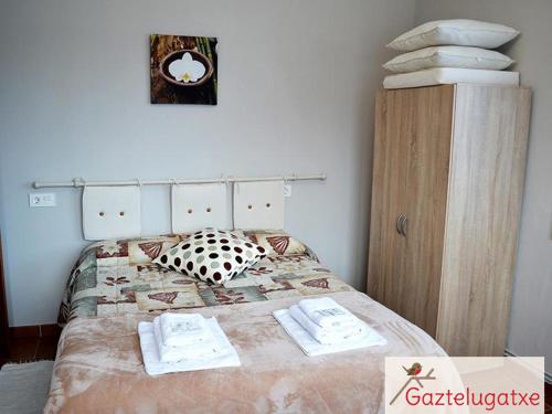a bedroom with a bed with two towels on it at Atxispe Etxea Casa Rural in Laukiz