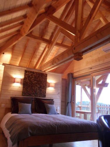 a bedroom with a bed in a room with wooden ceilings at Aura Cabana - Cabane spa perchée à 6 m de haut in Saint-André-dʼOlérargues