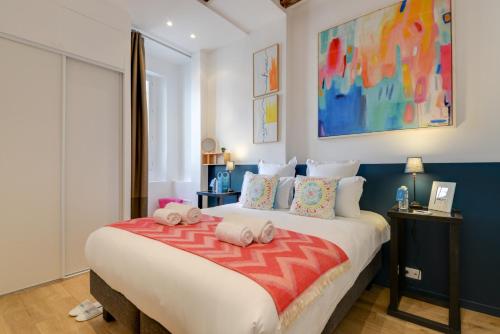 1 dormitorio con 1 cama grande y almohadas coloridas en Sweet Inn - Clery, en París