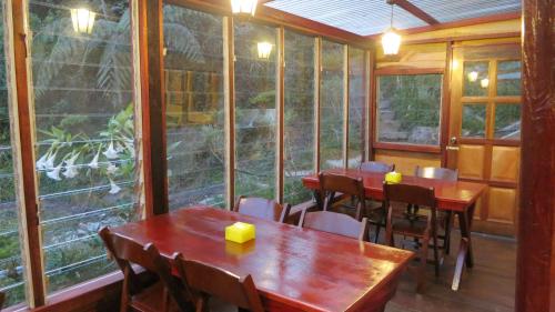 a restaurant with wooden tables and chairs and windows at Mile 36 Lodge in Kundasang