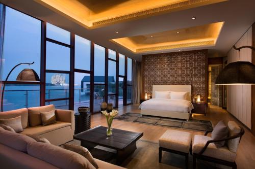 a bedroom with a bed and a living room at Yanqi Hotel, Managed by Kempinski in Huairou