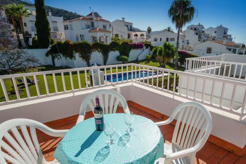 內爾哈的住宿－Villa Angie，阳台上的桌椅和一瓶葡萄酒