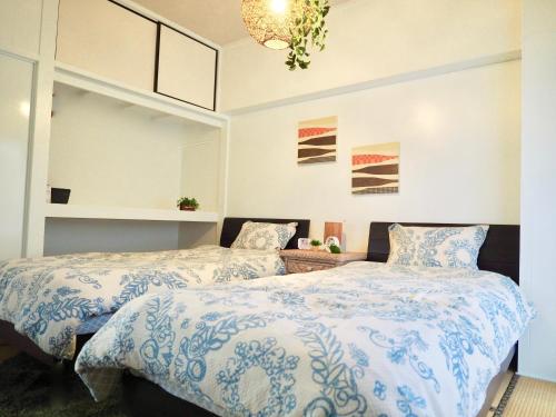 Duas camas sentadas uma ao lado da outra num quarto em Holiday Homes TSUBOYA 301 em Naha