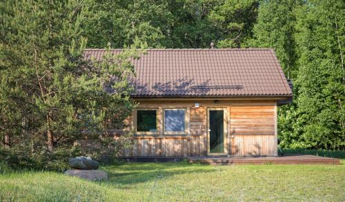 a small wooden cabin in the middle of a field at Vergi puhkemajad in Vergi