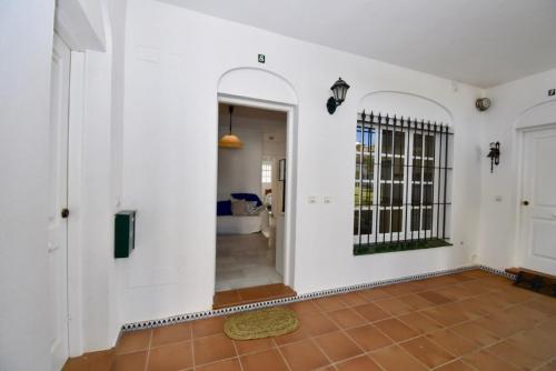 een hal met witte muren en een deur met een poort bij Apartamento La Barrosa - Chiclana - Urb. Pinar Atlántico in Chiclana de la Frontera