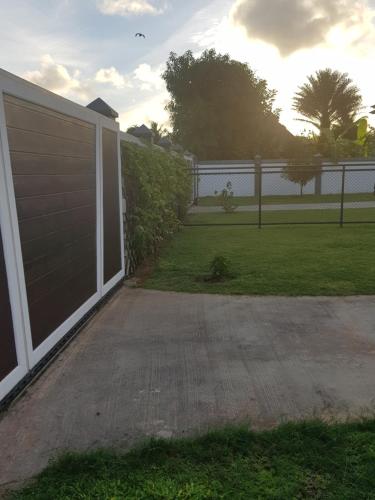 a garage door in a yard with a fence at Maison Cattleya Selfcatering Apartment in Mahe