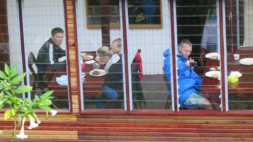 a group of people sitting at a table eating food at Mile 36 Lodge in Kundasang