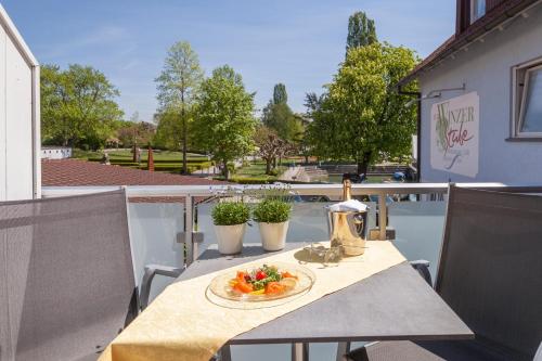 un plato de comida en una mesa en un balcón en Boutiquehotel zur Winzerstube - Adults Only en Hagnau