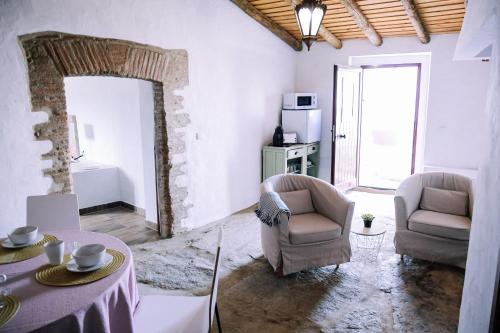 a living room with two chairs and a table at Casas da Faia - Nature Guest House in Arronches